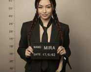 身着西装的女子摆出嫌犯照姿势