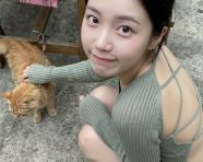 年轻的亚洲女生蹲坐在水泥地的庭院中