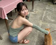 年轻的亚洲女生蹲坐在水泥地的庭院中