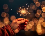 Sparklers at night at an event. may hands hold up a sparkler