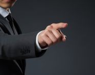 A business man in a suit pointing to something on a gray background, seo stock images for marketing campaigns