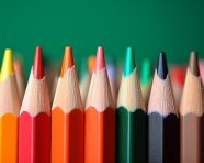 A stack of colored pencils on a desk with a green background, back to school stock images ai, back to school stock illustrations ai, back to school ai prompts