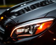 The headlights of a car are illuminated in the darkness, assembly line car production, assembly line car manufacturing