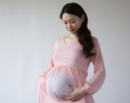 A pregnant lady with her belly against a white background, pregnant women pictures, maternity photos