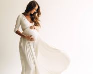 A pregnant woman is standing in front of a white background, pregnant women pictures, maternity photos