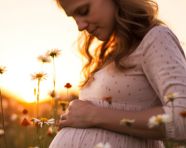 A pregnant woman stands in a field of wildflowers, pregnant women pictures, maternity photos