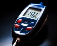 A close-up of a glucometer with a single drop, diabetes concept