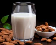 Almond milk in a glass with some almonds, almond image