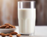 A glass of almond milk is seen from a distance, almond image
