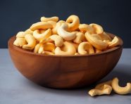 Cashews in wooden bowl on a grey surface, cashew image