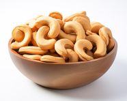Cashews in a wooden bowl on a white surface, cashew image