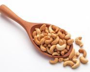 A wooden spoon full of cashews, cashew image
