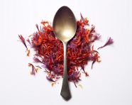 A spoon is filled with red saffron flowers, saffron flower image