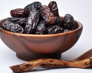 A bowl filled with some sweet dates are sitting on a white background, sweet dates image