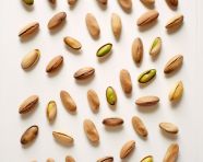 Several pistachios on white wooden background, pistachio nut image