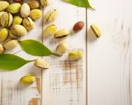 Pistachios on white wooden background stock photo, pistachio nut image