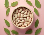 A bowl of pistachio nuts with leaves around it, pistachio nut image