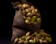 Pistachio nuts in a sack on black dark background in natural daylight photo, pistachio nut image