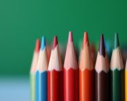 A stack of colored pencils on a desk with a green background, back to school stock images ai, back to school ai prompts