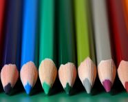 Colored pencil set loosely arranged on white background. colored pencils are not arranged exactly in a row.