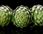 Three artichokes sit on a white backgrounds, artichoke image