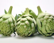 Three artichokes sitting on a white surface, artichoke image