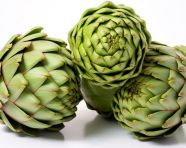 Three artichokes are being sliced on top of each other, artichoke image