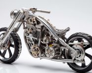 A chromed metal bike with gears is shown, found object art ideas
