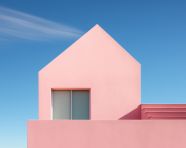 A pink house in front of a blue sky, postminimalism art