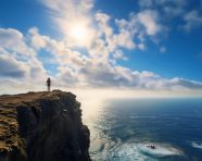 A person standing on a cliff overlooking the ocean, mental health