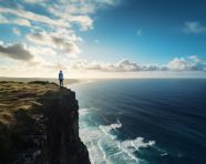 Person stands on cliff overlooking ocean, mental health