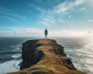 Person ponders the ocean from clifftop, mental health