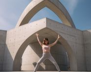 Young woman doing yoga in concrete jungle