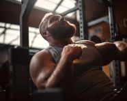 A slow-motion shot of a man bench pressing a heavy weight