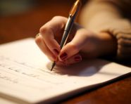 A close up of a students hand as they write down an idea