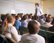 Professor lectures to students in large auditorium