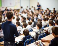 Teacher lecturing in front of large audience