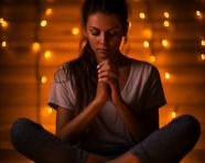 Person meditating in low light