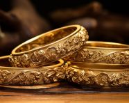Gold bangles on wooden board