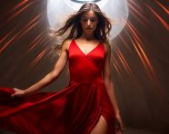 Graceful woman in red dress dancing