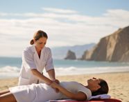 A wide angle shot of a person receiving a massage on a beach