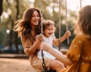 Mother and daughter swinging in the park