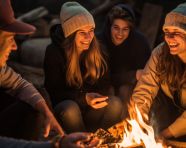 Friends laughing around campfire