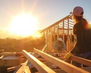 A volunteer is building a house for a family in need