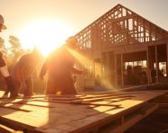 A volunteer is building a house for a family
