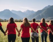 A group of people are standing in a field holding hands