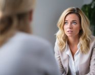 Woman sits in a therapists office, her face turned