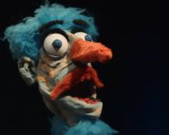 Hand puppet with orange nose and eyebrows