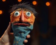 A hand puppet with an orange nose and eyebrows